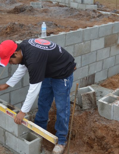a worker uses a level on a concrete block project