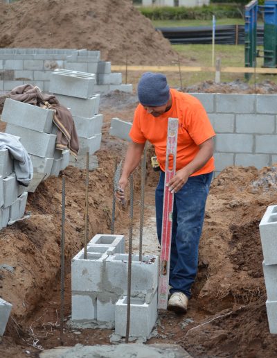 a worker uses a level on a concrete block project