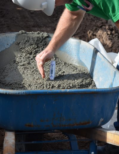 a worker checks cement in a wheelbarrow