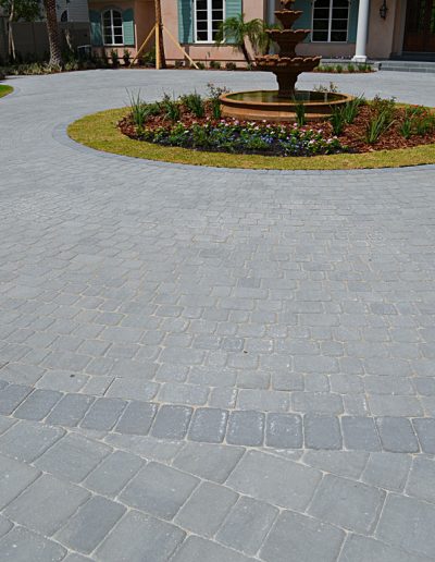 a circular driveway surrounds a landscaped island with a fountain