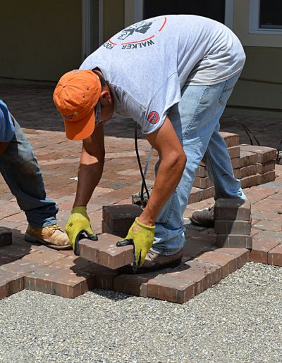 a worker lays pavers in a project