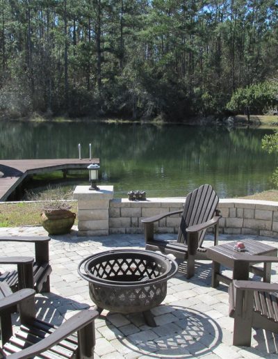 circular patio created with pavers, surrounded on one side by a seat wall