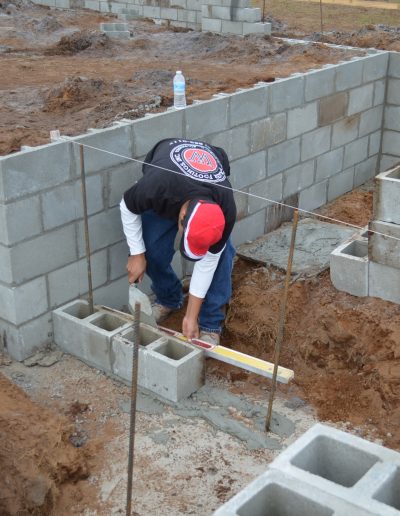 a worker uses a level on a concrete block at a project by Walker Footings