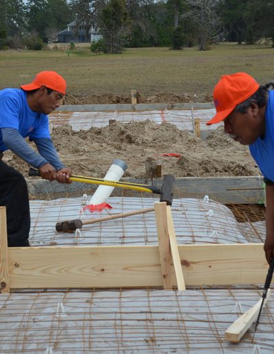 two Walker Footings workers lean in to their work on a concrete footing