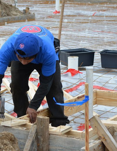 a worker hammers nails