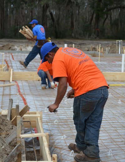 several workers work on a concrete footing