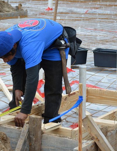 a worker measures wood with a measuring tape