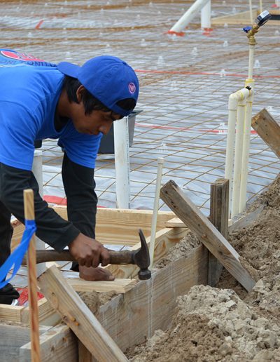 a worker hammers wood on a Walker Footings project