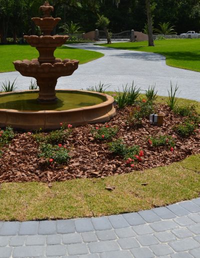 circular driveway around a fountain with landscaping