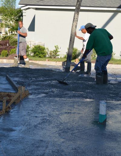 three workers spread concrete