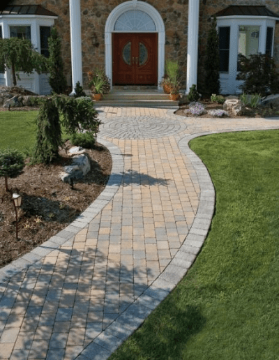 a curved walkway leads to the entrance of a house