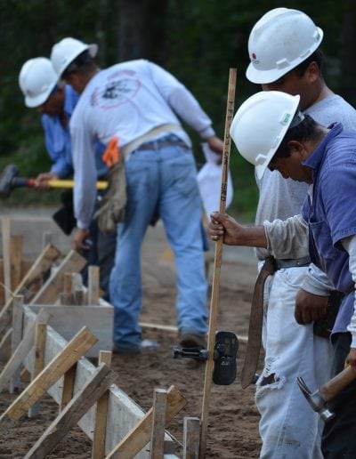 several workers in hardhats look over work on project